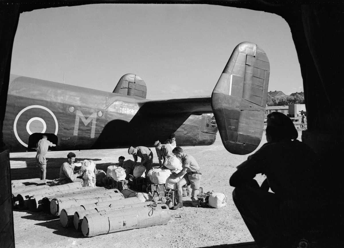 British soldiers and Yugoslav partisans transferring parachute containers and supply bundles to a Handley Page Halifax Mark II bomber during WWII in Italy