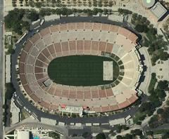 Aerial view of Los Angeles Memorial Coliseum with surrounding park and cityscape