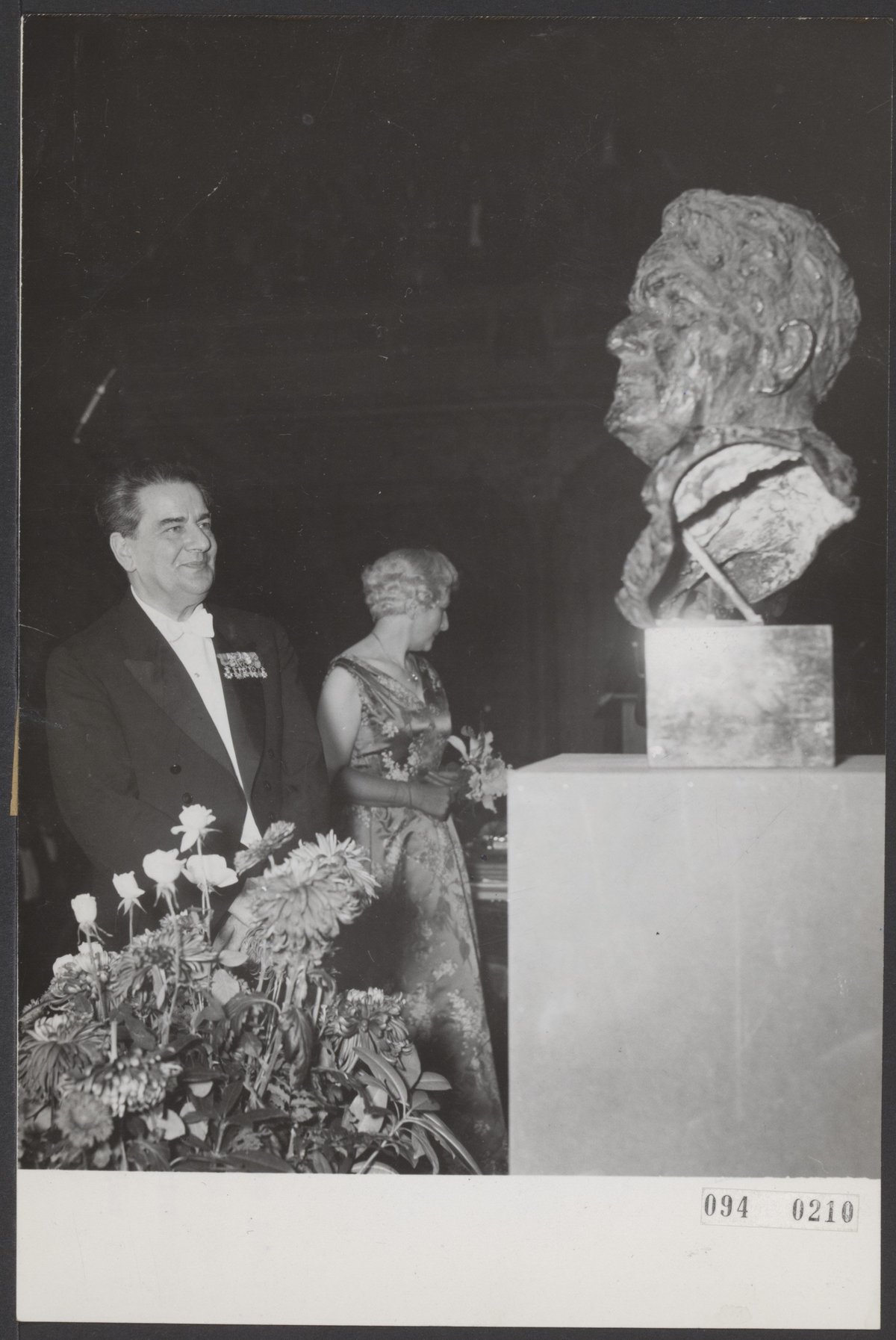 Black and white photo of 25th anniversary celebration of conductor Eduard van Beinum receiving a bust sculpture by Mari Andriessen at Concertgebouw Amsterdam