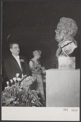 Black and white photo of 25th anniversary celebration of conductor Eduard van Beinum receiving a bust sculpture by Mari Andriessen at Concertgebouw Amsterdam