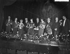 Black and white photograph of the farewell ceremony of Familie Doorsnee at Concertgebouw in Amsterdam in 1958 showing radio cabaret artists Liana Dorana, Kees Brusse, Hetty Blok, Cees Laseur, and Wim Ibo