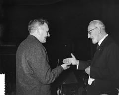 Award ceremony for artists' resistance at the Concertgebouw in Amsterdam, with professor Wieger Bruin presenting an award to V. Elenbaas, black and white photograph from 1961