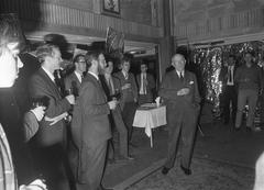 Black and white photo of the 5th Congress of the Social Interacademiale on the student ship Caledonia showing Wethouder Koets in conversation with Chairman Winters and Vice Chairman Pieter