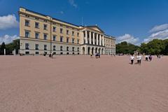 Royal Palace in Oslo surrounded by greenery under clear blue sky