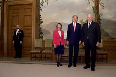 U.S. Secretary of State John Kerry posing with King Harald and Queen Sonja of Norway at the Royal Palace in Oslo on June 15, 2016, with an attendant standing by