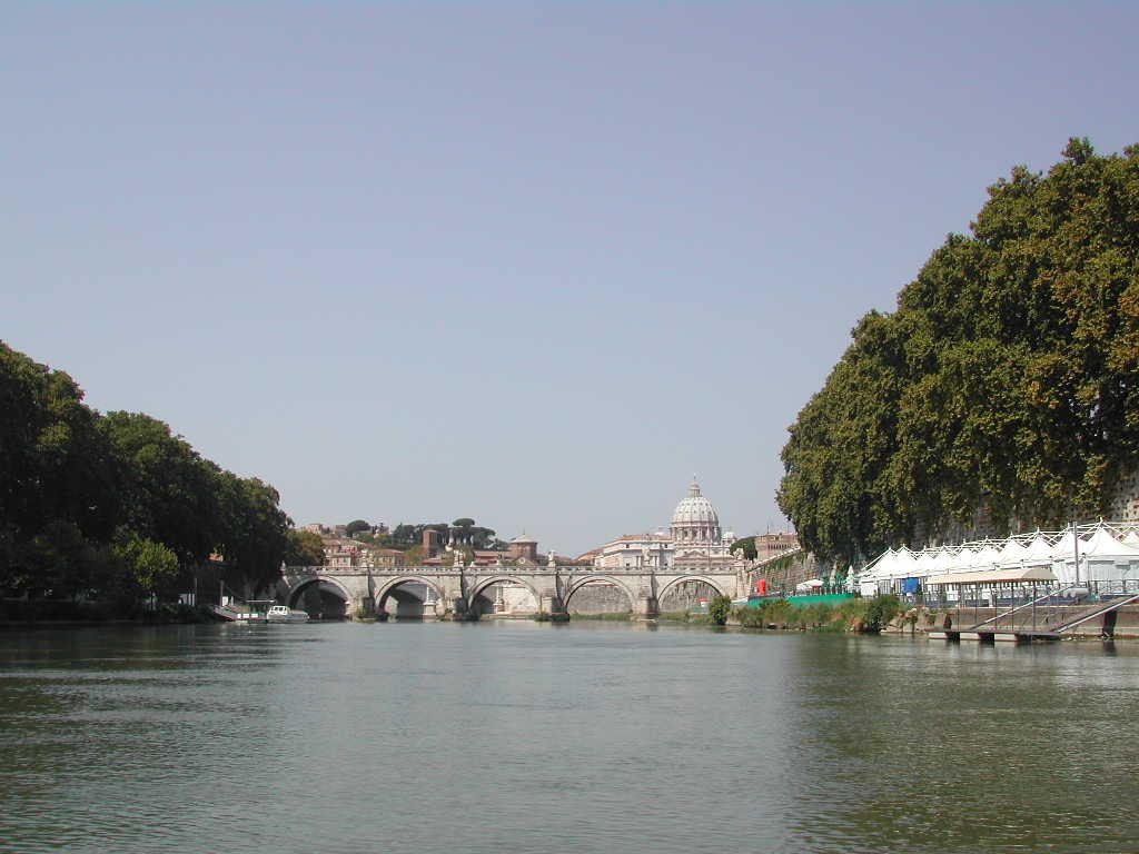Boats on the Tiber River near Ponte Sant'Angelo with St. Peter's Basilica in Rome