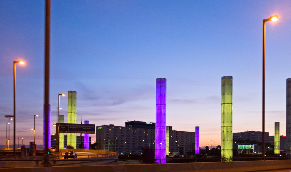 Lighted decorative columns at highway entrance to LAX airport in the morning