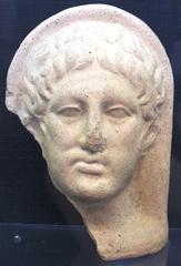 Ancient protome sculpture with intricate facial details