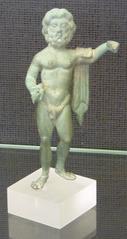 Figurine of a deity with outstretched arms on a pedestal