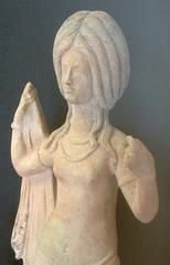 Clay figurine holding a spear on a ceramic vessel