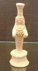 Ancient terracotta figurine of a standing woman with raised arms