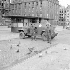 British Army crew feeding pigeons from Humber Light Reconnaissance Car in Hamburg 1945