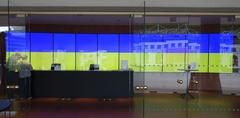 Foyer entrance of Schauspielhaus Düsseldorf with yellow and blue reflections representing Ukraine flag colors and mirrored stage setting from the outdoor play 'Der Diener zweier Herren' in May 2022