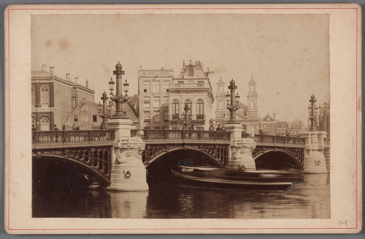 New stone Blauwbrug bridge over the Amstel river in Amsterdam with Waterlooplein and Mozes- en Aäronkerk in view