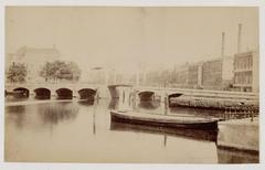 View of the Amstel river towards Blauwbrug bridge in Amsterdam with Waterlooplein on the right