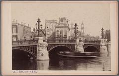 View of the new stone Blauwbrug bridge over the Amstel River towards Waterlooplein with Mozes en Aäronkerk church and the building of Levisson company at Amstel 27 in Amsterdam in 1884