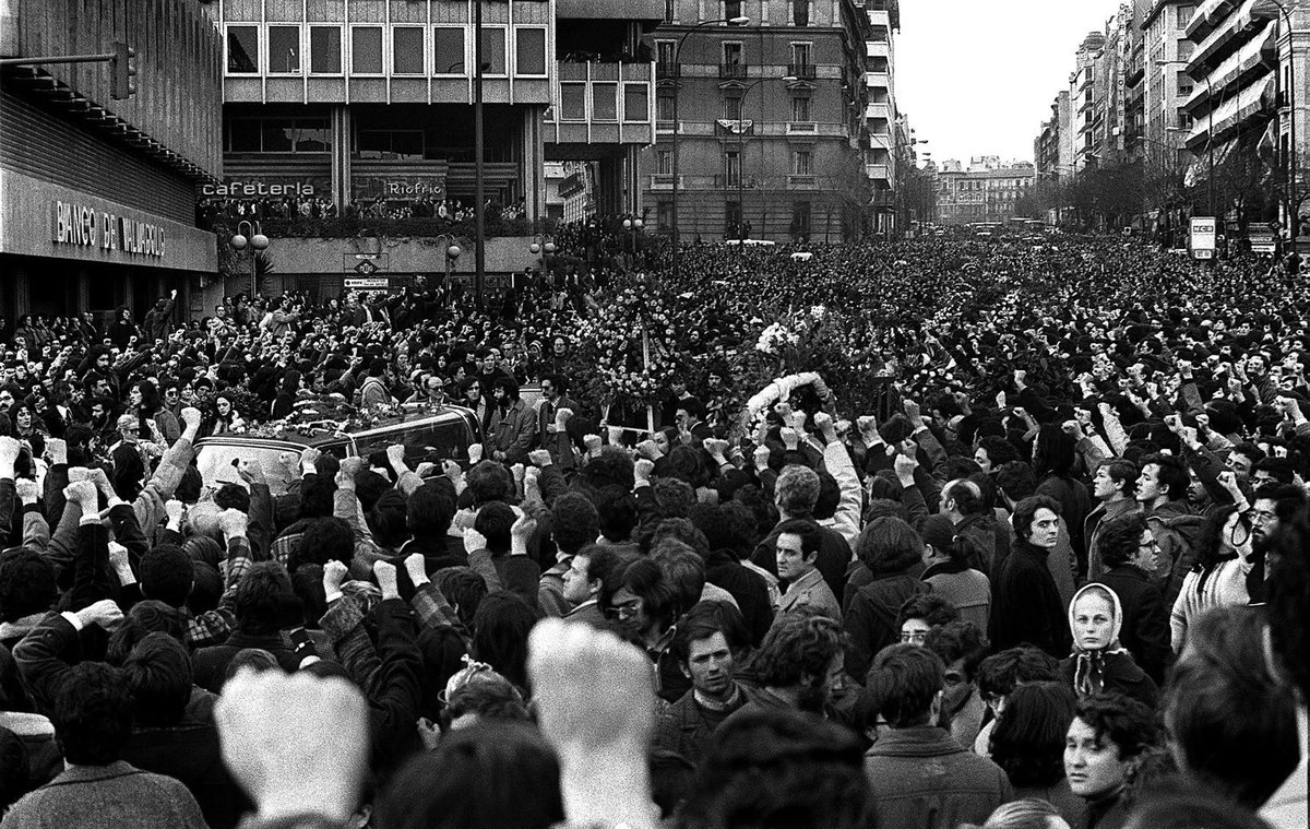 Massive silent crowd with raised fists during the Atocha massacre funeral procession in Madrid