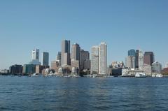 Boston skyline viewed from the water on a clear sunny day with sailboats and Long Wharf visible