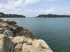 Two drumlins of World’s End connected by a low tombolo with rocky foreground of Rocky Neck and algae at water edge