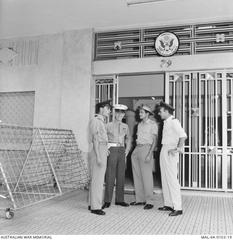 RAAF Transport Flight pilots and RAF officer speaking with US Marine guard outside US Embassy in Saigon during Vietnam War