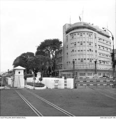 U.S. Embassy building in Saigon in 1966 with American flags and large group of people outside