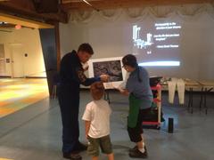 Astronaut Steve Bowen pointing to Boston city from space to a visitor at Boston Children's Museum