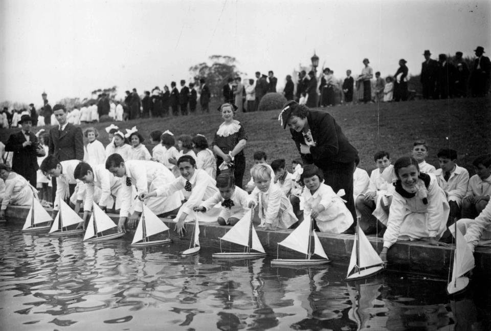 Primary school children launching scale model sailboats in the fountain at Plaza Rubén Darío in Buenos Aires, Argentina