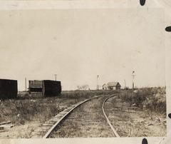 Boxcars on train tracks near a house after a hurricane