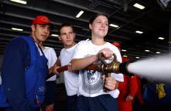 Midshipman Melissa Lucas receiving fire fighting training from Damage Controlman 3rd Class Mike Vega aboard USS John C. Stennis in the Pacific Ocean