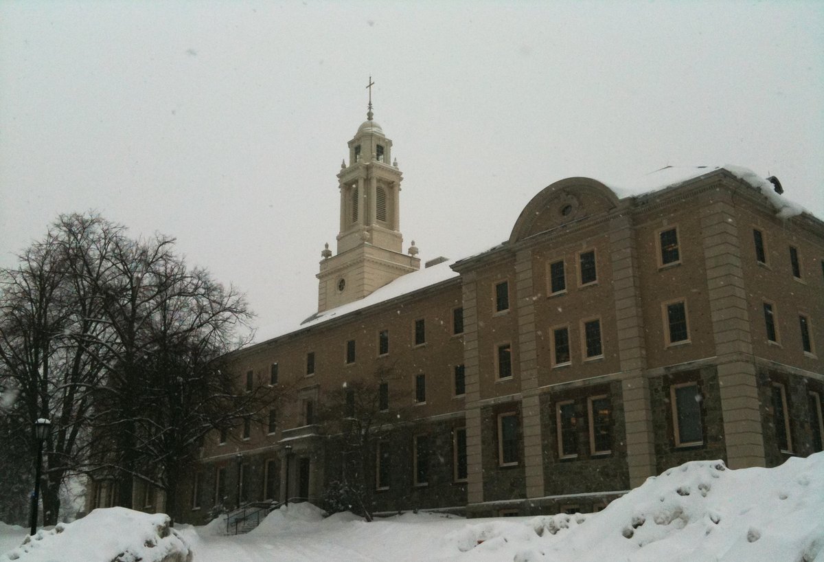 Boston College School of Theology and Ministry building in winter with snow-covered grounds and trees
