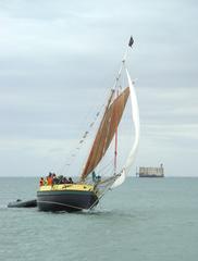 Boyard vintage sailing ship with red sails on calm sea