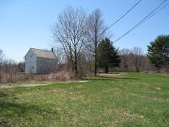 Historic Brook Farm farmhouse with white exterior and trees surrounding