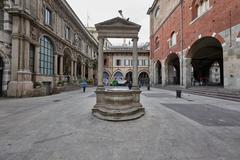 Piazza dei Mercanti square in Milano with historic buildings and people walking