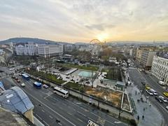 View of Erzsébet tér in Budapest with historic buildings and trees under a clear sky