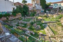 Excavated ancient ruins at the north side of the Ancient Agora of Athens including remains of Stoa Poikile with Doric and Ionic columns, archaeological site under open sky on August 13, 2020