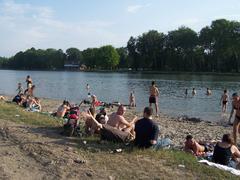 Beach by Nowohucki Lagoon with people relaxing and swimming on a sunny day