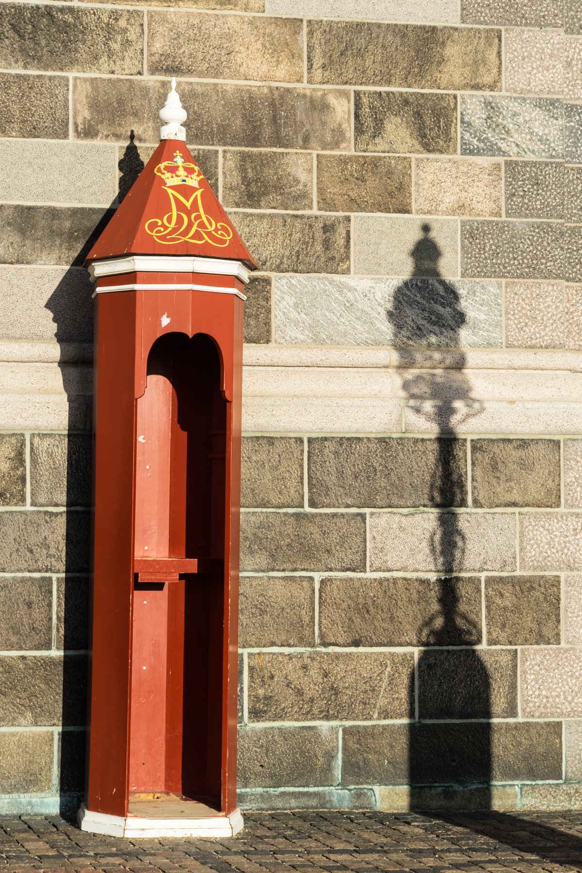 Empty sentry box casting shadow of lamp post at Christiansborg in Copenhagen Denmark