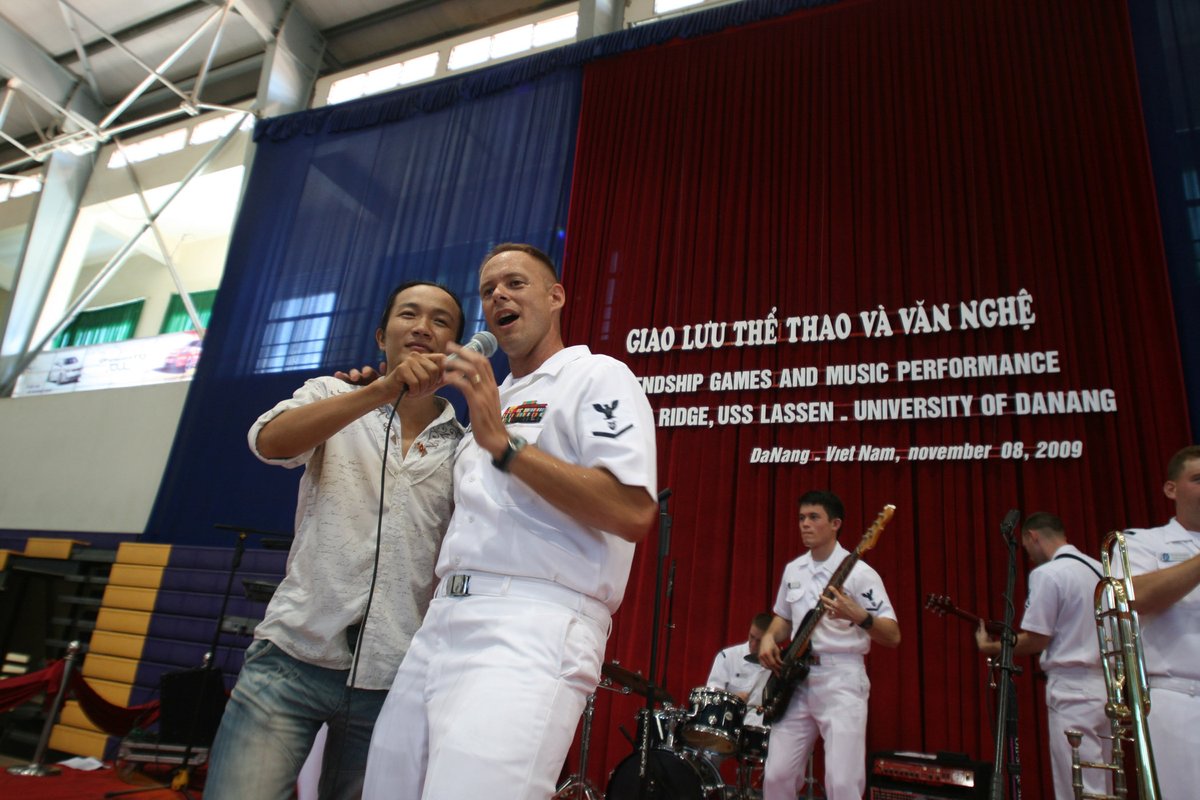 Petty Officer 3rd Class Spencer Haasenritter singing with student at University of Da Nang band performance