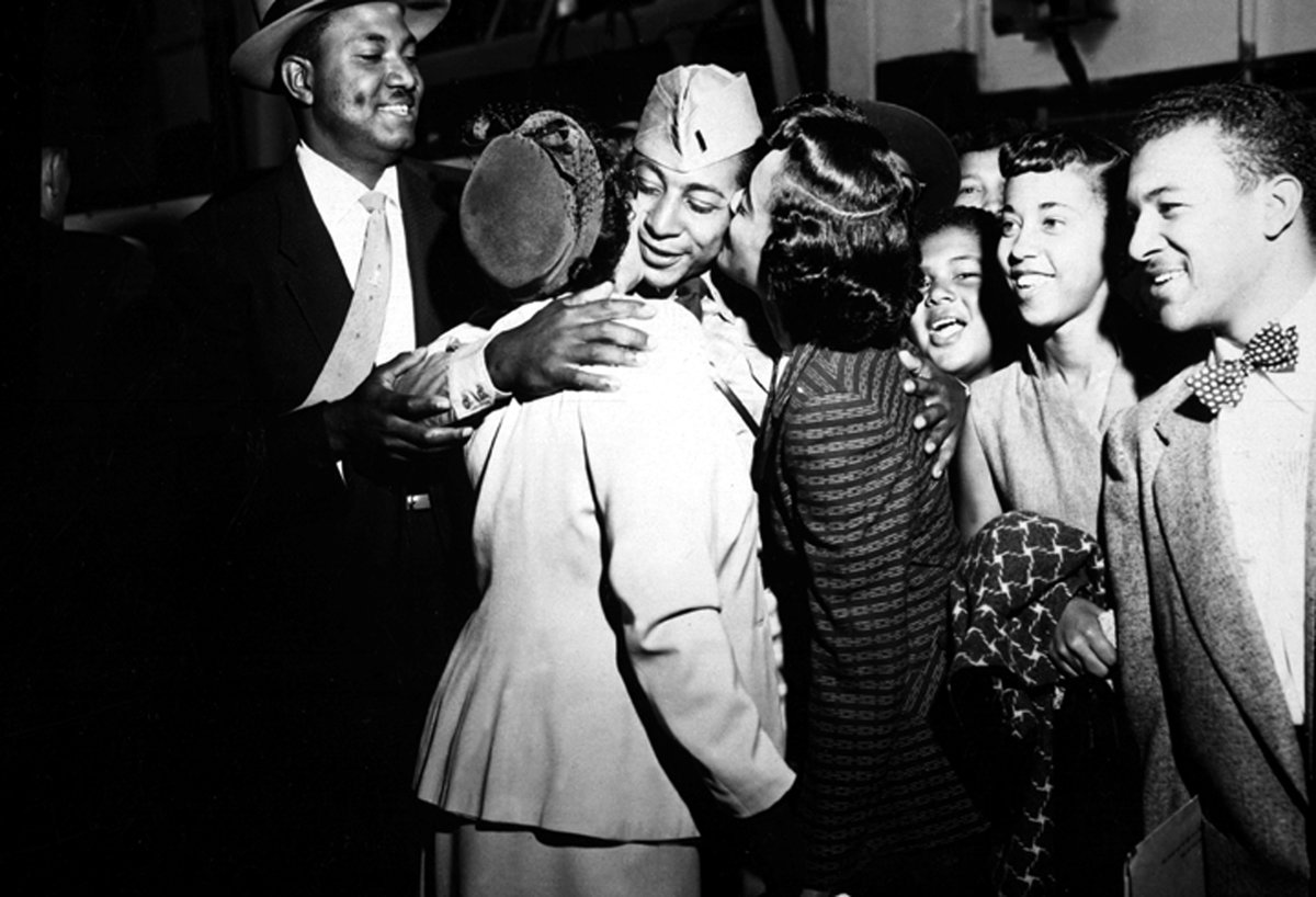 1st Lt. Alvin Anderson embracing his mother and sister upon returning home from imprisonment aboard USNS Marine Phoenix at Fort Mason