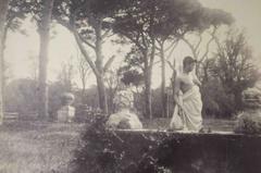 Half clad boy in the garden of Castello Chigi villa with visible busts in the background