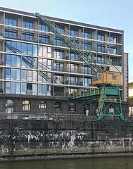 Old crane at Severinsbrücke Bridge in Cologne with Halle 11 building in background