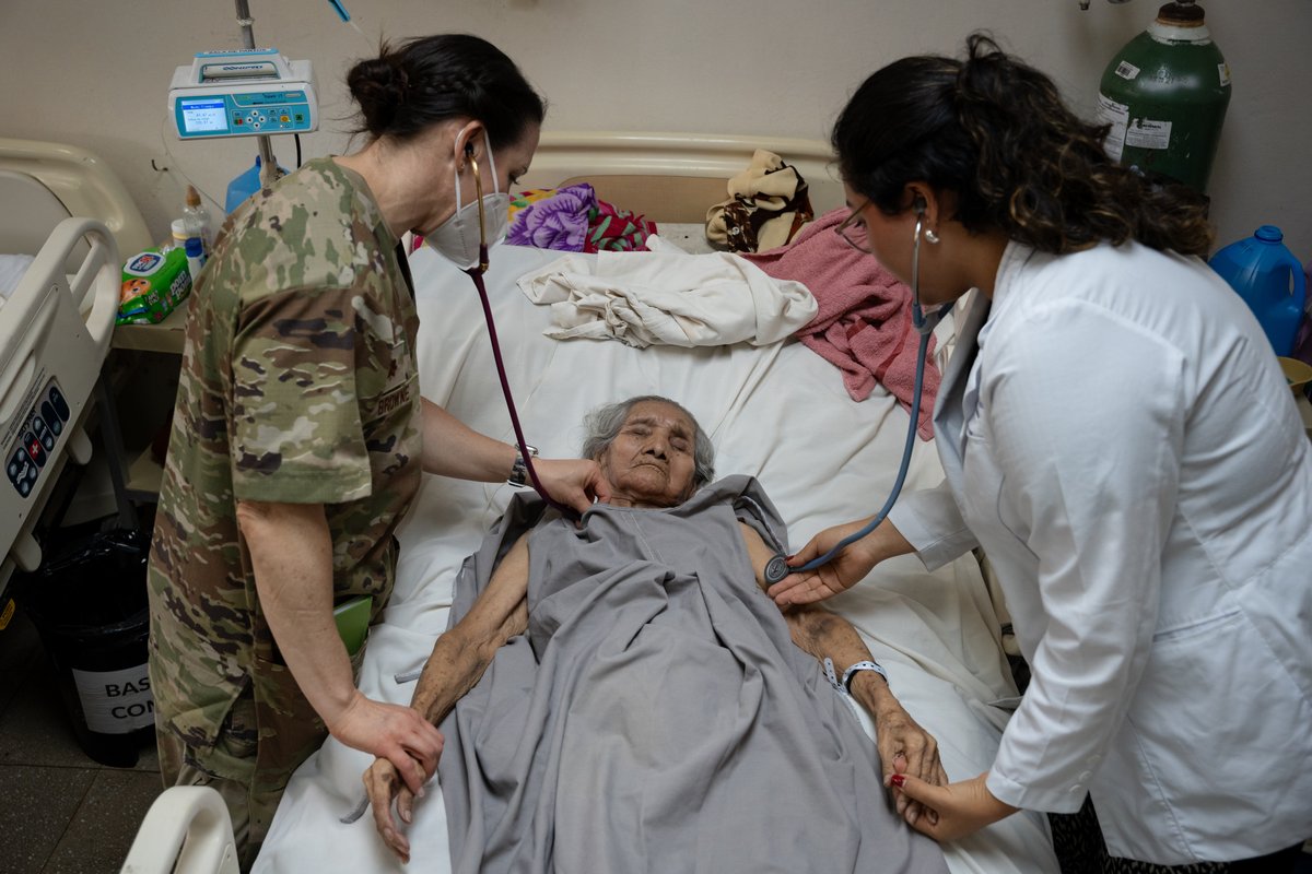 U.S. Air Force medical personnel using stethoscopes to examine patient at San Bartolo National Hospital El Salvador