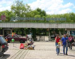 Entrance gate of Sofia Zoo with sign and surrounding greenery