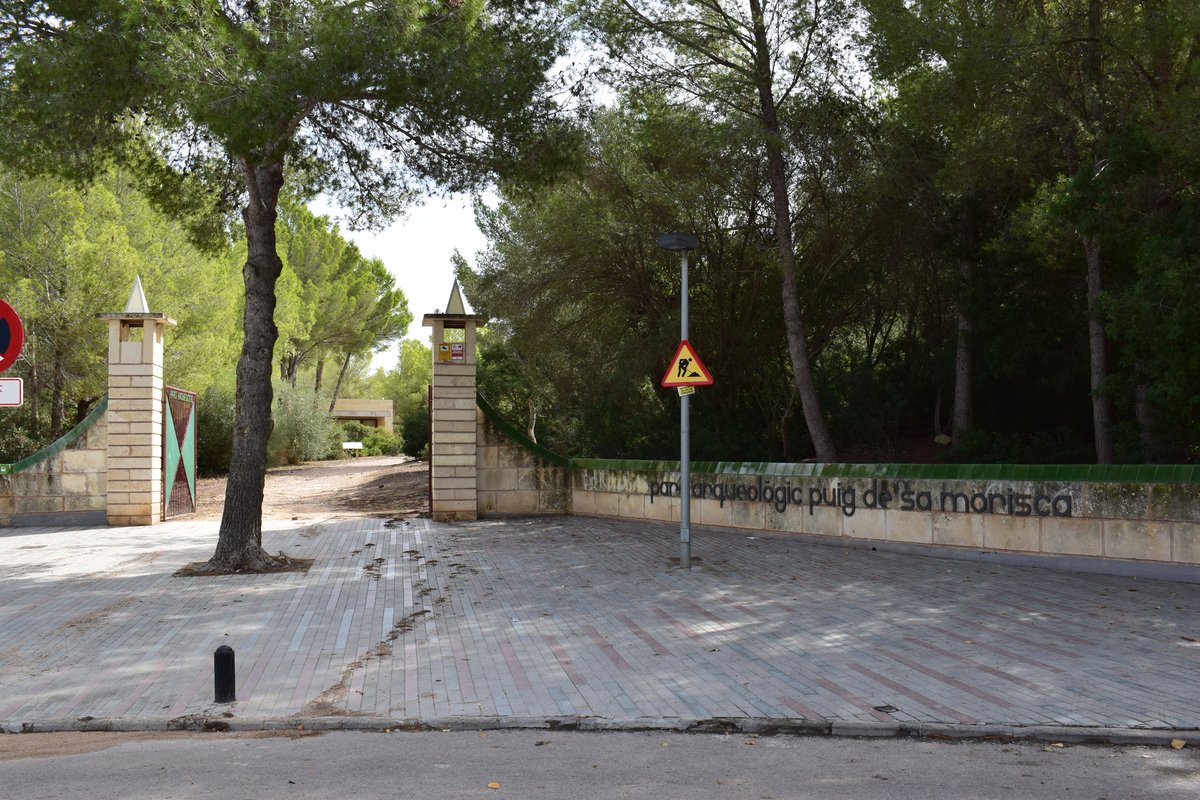 Entrance to Puig de Sa Morisca Archaeological Park in Palma Spain with stone walls and clear blue sky