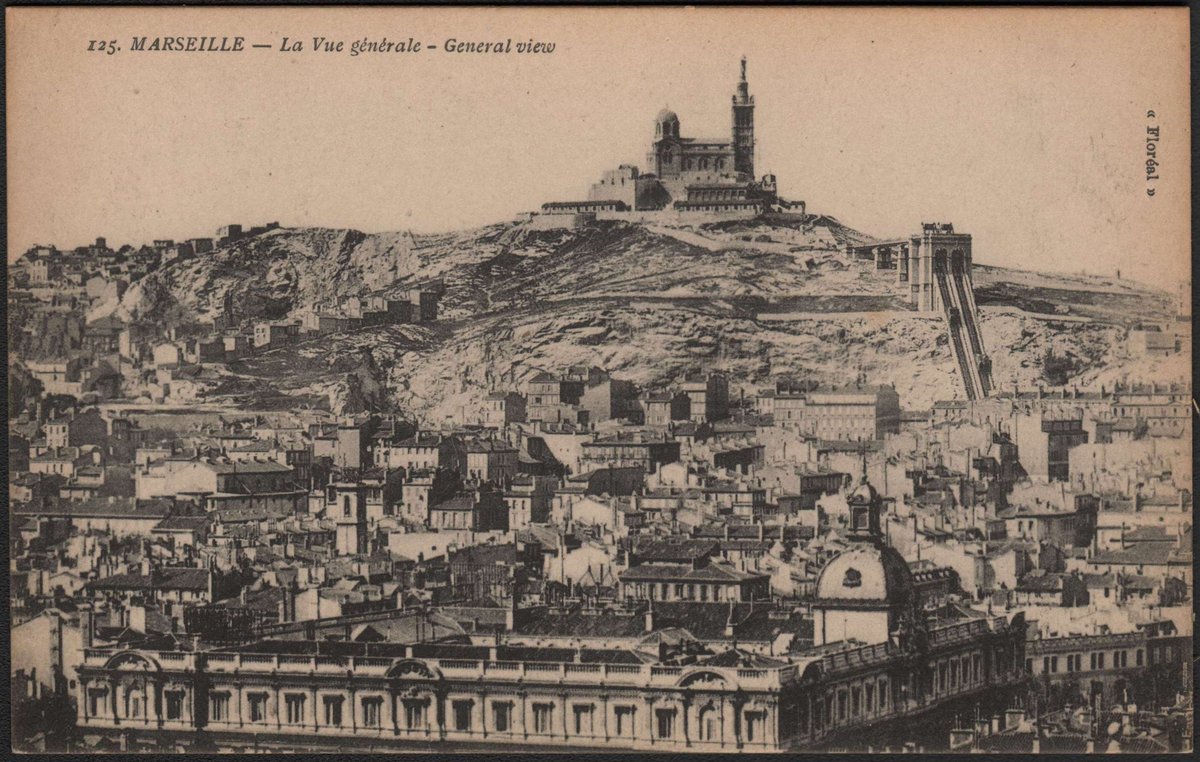 General view of Marseille city with buildings and coastline under a clear sky