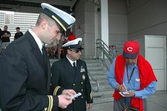 Chuck Harmon signing autograph at Cincinnati Reds game with Navy personnel
