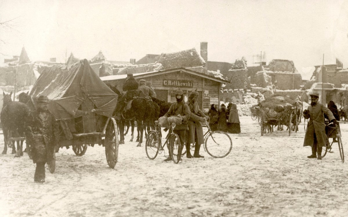 World War I soldiers with bicycles and horses near the destroyed Soldau in East Prussia, snowy scene