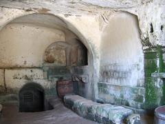 Interior view of a traditional cave dwelling with a water cistern in Matera